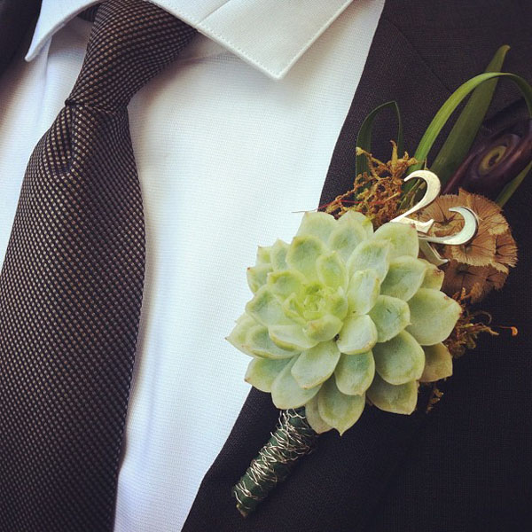 Lily grass, fiddle head fern, moss, and scabiosa pod, and a succulent, The Number 22 was added for the groom it was his late fathers number. wrapped with silver bullion wire.. I charged 28.00
