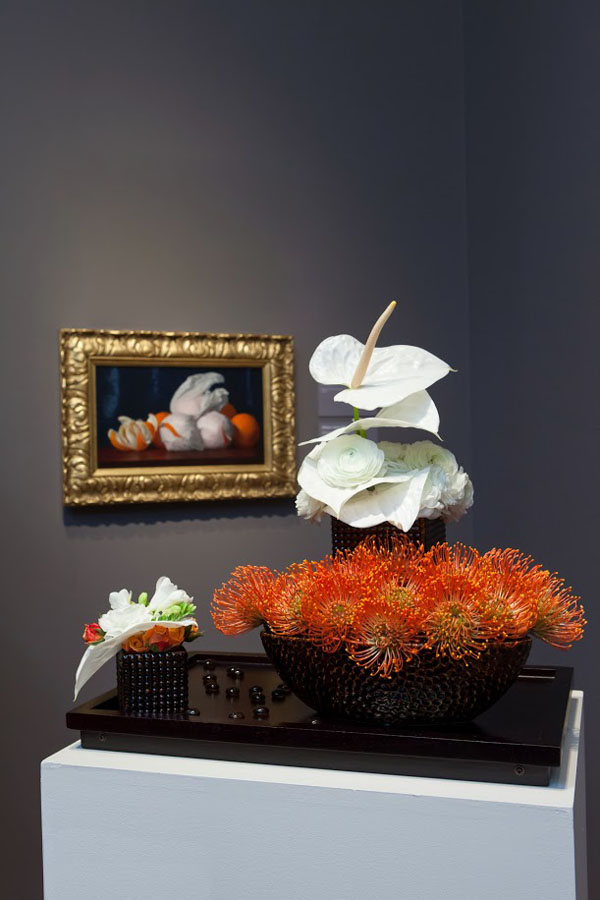 San Francisco Bouquets To Art, William Joseph McCloskey, Oranges in Tissue Paper, c. 1890. Oil on canvas. Fine Arts Museums of San Francisco, gift of Mr. and Mrs. John D. Rockefeller, III.  Floral design by Friends of Fioli. Photograph Â© Greg A. Lato / latoga photography