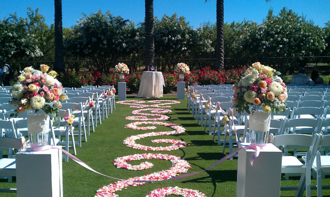 Designed by Fleurie of Reedley California, Wedding Ceremony aisle with petals placed in scrolls pattern.