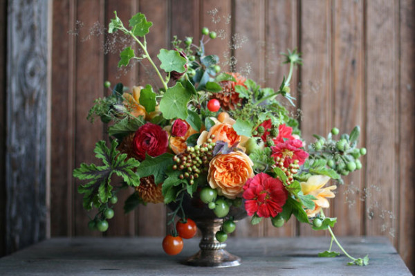 Floret Flower Farm - bronze compote flower arrangement of orange peach garden roses, tomatoes, cranberry viburnum, red ranunculus, nasturtium