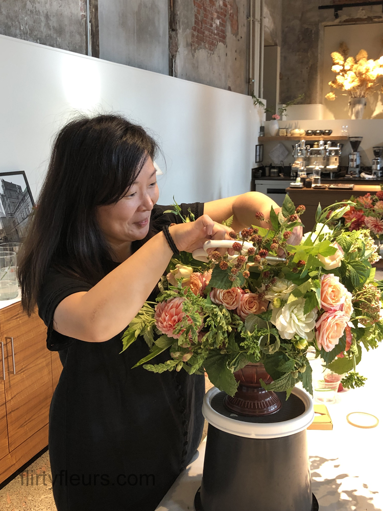 Flirty Fleurs Floral Design Class in Seattle, Washington -  student working on flower centerpiece