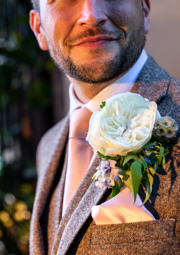 The groom’s button hole or boutonnière full of meaning – a symbol of beauty in nature and of love undefined, captured in a single bloom of Ella (Auswagsy), one of our newest varieties, chosen to match the bride’s bouquet. ...We didn’t want to leave out the groom who plays an equally important role!