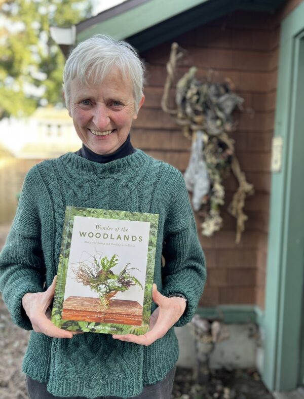 Francoise Weeks holding her book Wonder of the Woodlands, the art of seeing and creating with nature